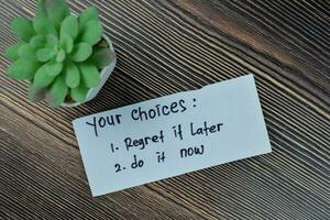 Concept of your choices - regret it later or do it now write on sticky notes isolated on Wooden Table. photo