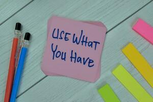 Concept of Use What You Have write on sticky notes isolated on Wooden Table. photo