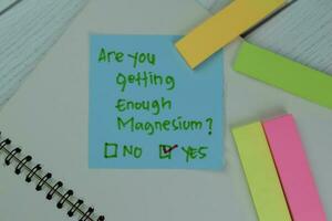 Are You Getting Enough Magnesium No or Yes write on sticky notes isolated on Wooden Table. photo