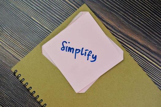 Concept of Simplify Reminder write on sticky notes isolated on Wooden Table. photo