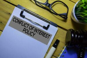 Conflict of Interest Policy text on Document form and Gavel isolated on office desk. photo