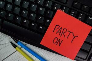 Party ON write on sticky notes isolated on Wooden Table. photo