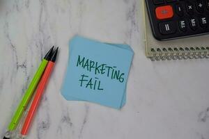 Marketing Fail write on sticky notes isolated on Wooden Table. photo