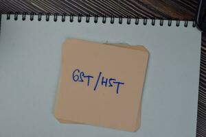 GST or HST write on sticky notes isolated on Wooden Table. photo