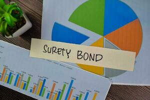 Concept of Surety Bond write on sticky notes isolated on Wooden Table. photo