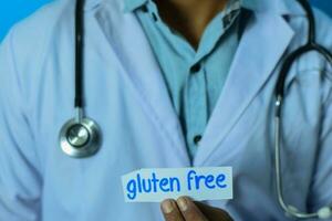 médico participación un tarjeta con texto gluten gratis. médico y cuidado de la salud concepto. foto