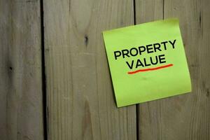 Property Value text on sticky notes with wooden background photo