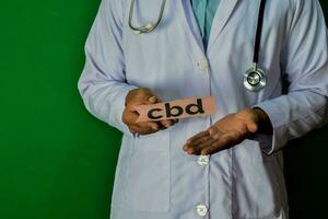 doctor standing on Green background. Hold the CBD paper text. Medical and healthcare concept. photo