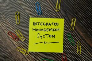 integrated management system write on sticky notes isolated on office desk. photo