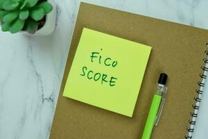 Concept of Fico Score write on sticky notes isolated on Wooden Table. photo