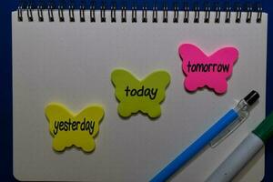 Yesterday, Today, Tomorrow write on sticky notes isolated on Office Desk photo