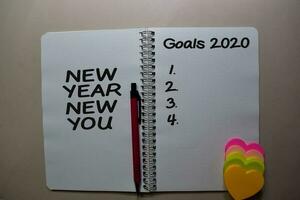 New Year New You and Goals 2020 write on a book isolated on Office Desk photo