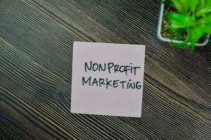 Concept of Nonprofit Marketing write on sticky notes isolated on Wooden Table. photo