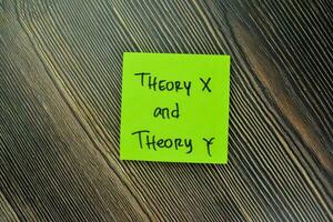 Concept of Theory X and Theory Y write on sticky notes isolated on Wooden Table. photo