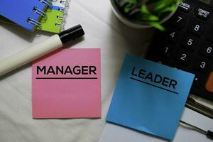 Manager or Leader on sticky Notes isolated on office desk. photo