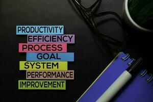 productividad, eficiencia, proceso, meta, sistema, actuación, mejora texto en pegajoso notas aislado en negro escritorio. mecanismo estrategia concepto foto