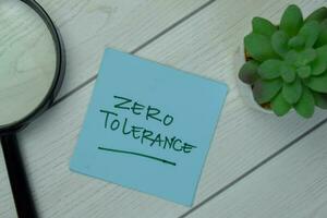 Zero Tolerance write on sticky notes isolated on Wooden Table. photo