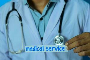 Doctor holding a card with text medical service. Medical and healthcare concept. photo