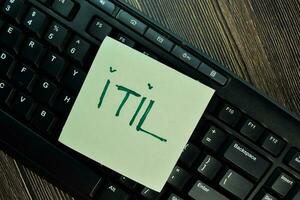 ITIL write on sticky notes isolated on Wooden Table. photo