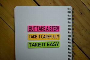 Take it East, Take it Carefully But Take a Step write on a sticky note isolated on wooden background. photo