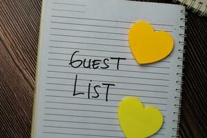 Guest List write on a book with keywords isolated wooden table. photo