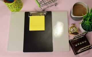 Top view of the notepad and clipboard with a marker drawing on a pink table, preparing to do homework. Drawing Working Desk Concept. photo