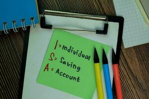 ISA - Individual Saving Account write on sticky notes isolated on Wooden Table. photo