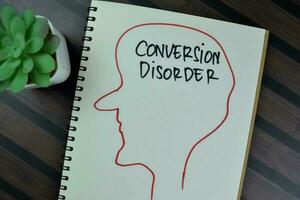 Concept of Conversion Disorder write on a book isolated on Wooden Table. photo