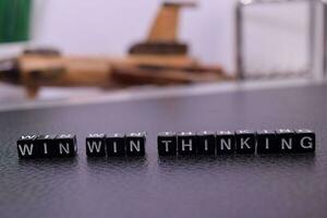 Win Win Thinking on wooden blocks. Cross processed image with business concept on White background photo