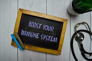 Boost Your Immune System write on a chalkboard isolated on office desk. photo