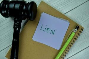 Concept of Lien write on sticky notes with gavel isolated on Wooden Table. photo