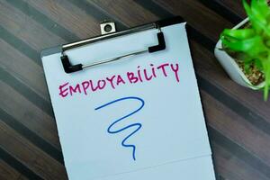 Concept of Employability write on paperwork isolated on Wooden Table. photo