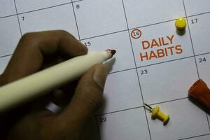 Daily Habits text on white calendar background. Reminder or schedule concept photo