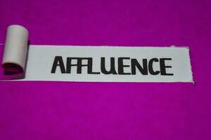 Affluence text, Inspiration and positive vibes concept on purple torn paper photo