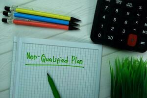 Non-Qualified Plan write on a book isolated on office desk. photo
