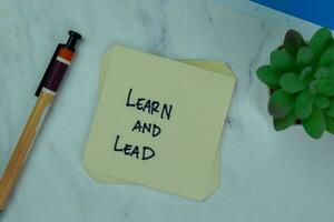 Concept of Learn and Lead write on sticky notes isolated on Wooden Table. photo