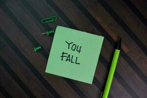 You Fall write on sticky notes isolated on Wooden Table. photo