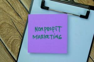 Concept of Nonprofit Marketing write on sticky notes isolated on Wooden Table. photo