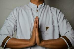 Close up Asian man shows hand gestures it means Prayer isolated on white background photo