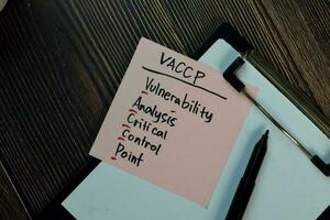 VACCP - Vulnerability Analysis Critical Control Point write on sticky notes isolated on Wooden Table. photo