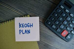 Keogh Plan write on sticky notes isolated on Wooden Table. photo
