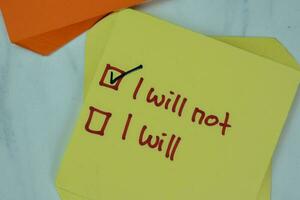 Concept of I will Not or I Will write on sticky notes isolated on Wooden Table. photo