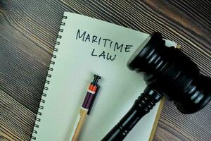 Concept of Maritime Law write on a book gavel isolated on Wooden Table. photo