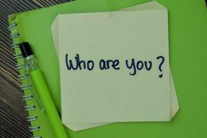 Concept of Who Are You Identity write on sticky notes isolated on Wooden Table. photo