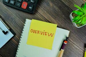 Concept of Overview write on sticky notes isolated on Wooden Table. photo