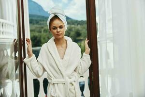 pretty woman in a white robe on the balcony bit on green nature Relaxation concept photo