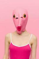 moderno Víspera de Todos los Santos disfraz en un silicona máscara en el forma de un rosado pescado cabeza en un sexy traje. el concepto de un loco Mira foto