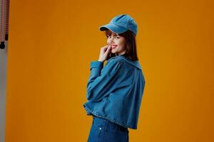 Beauty Fashion woman in a cap and denim jacket posing color background unaltered photo