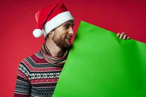 Cheerful man in a santa hat holding a banner holiday isolated background photo