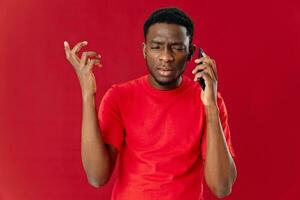 man talking on the phone in a red t-shirt communication studio close-up photo